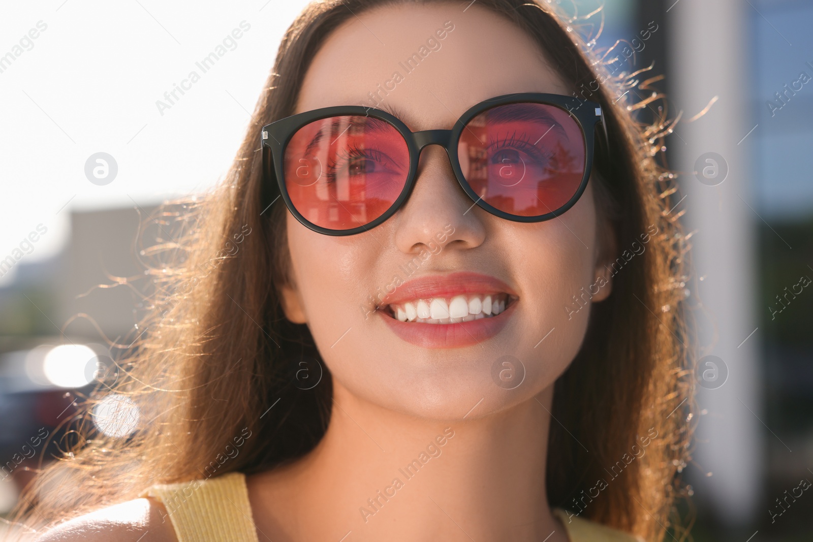 Photo of Beautiful smiling woman in sunglasses outdoors on sunny day