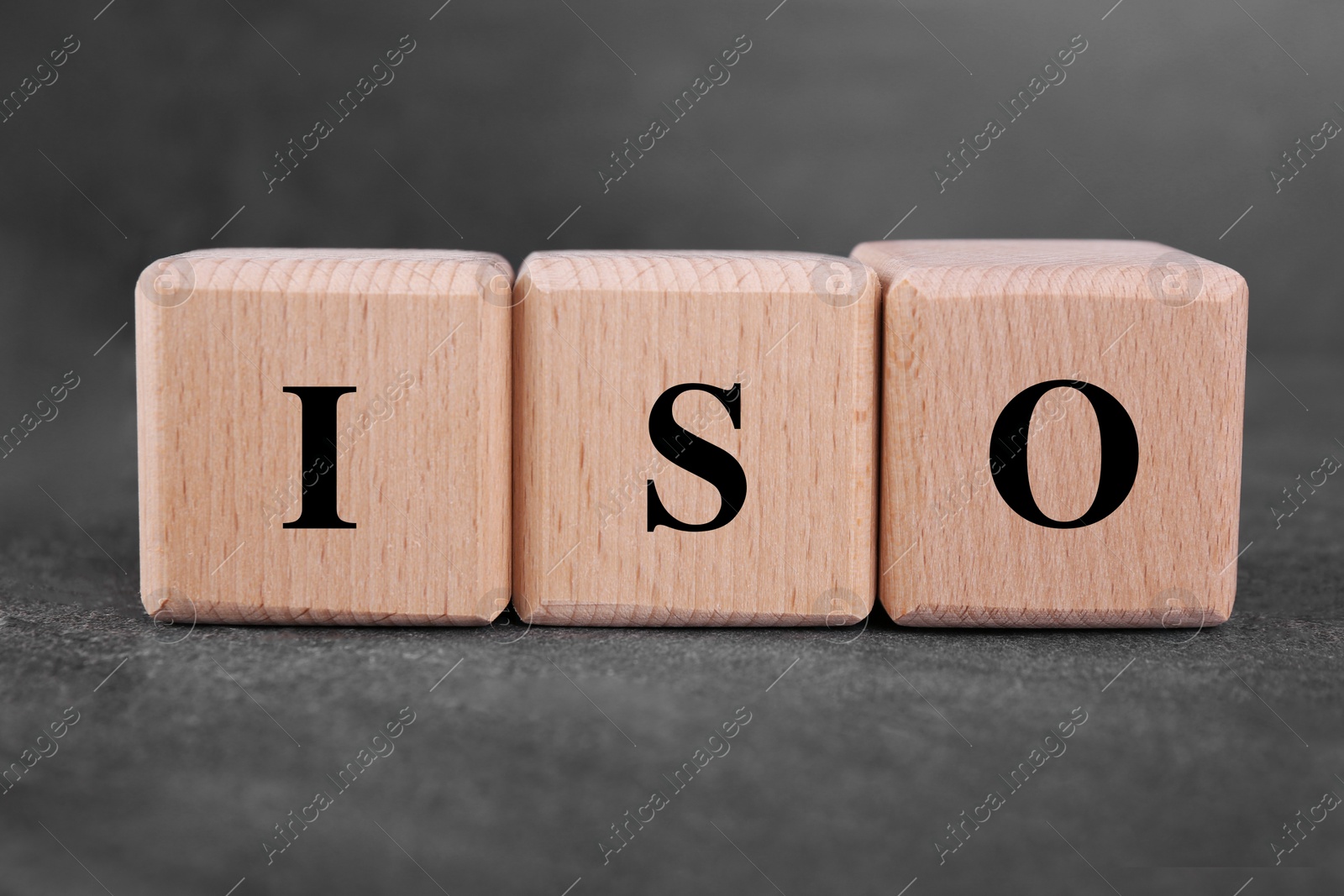 Photo of International Organization for Standardization. Cubes with abbreviation ISO on gray textured table