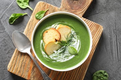 Fresh vegetable detox soup made of spinach with croutons in dish served on table, flat lay