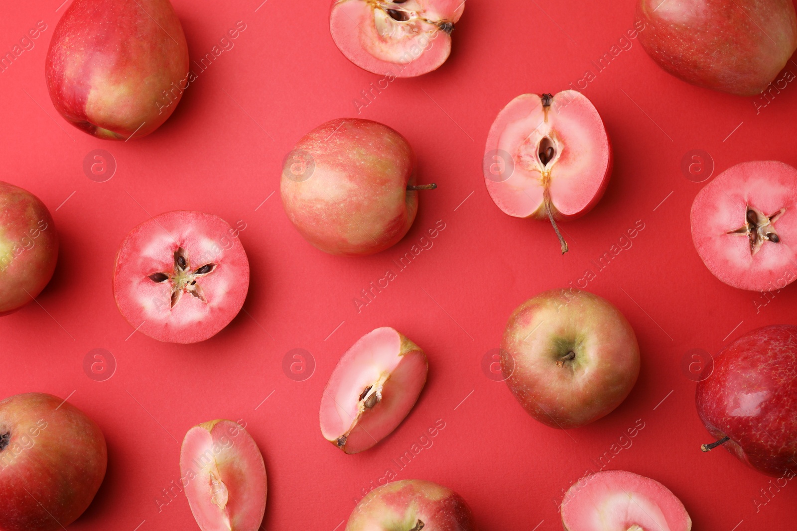 Photo of Tasty apples with red pulp on color background, flat lay