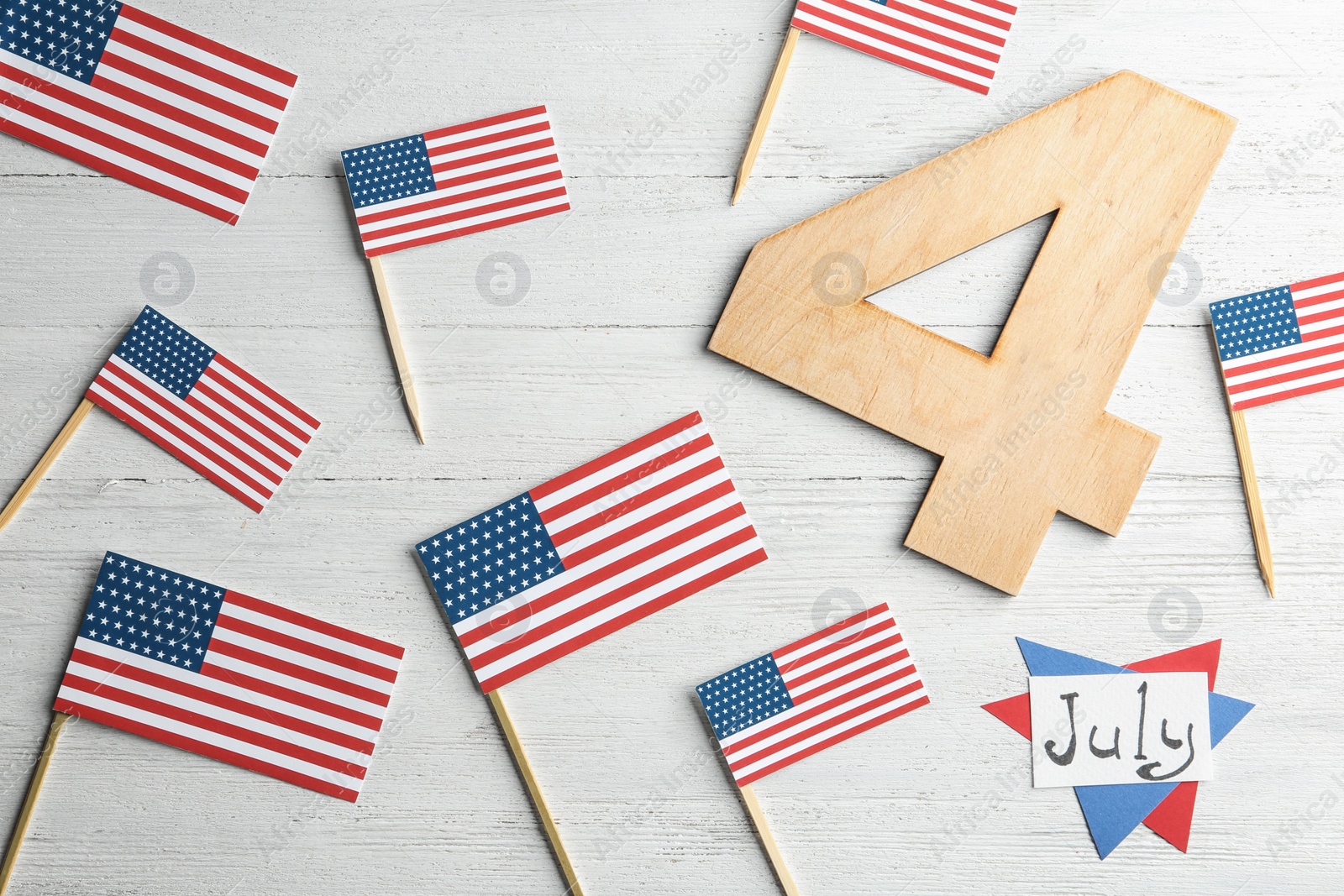 Photo of Phrase "4 July" made of wooden number and card with USA flags on table, flat lay. Happy Independence Day