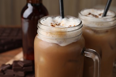 Photo of Delicious iced coffee with chocolate syrup, closeup