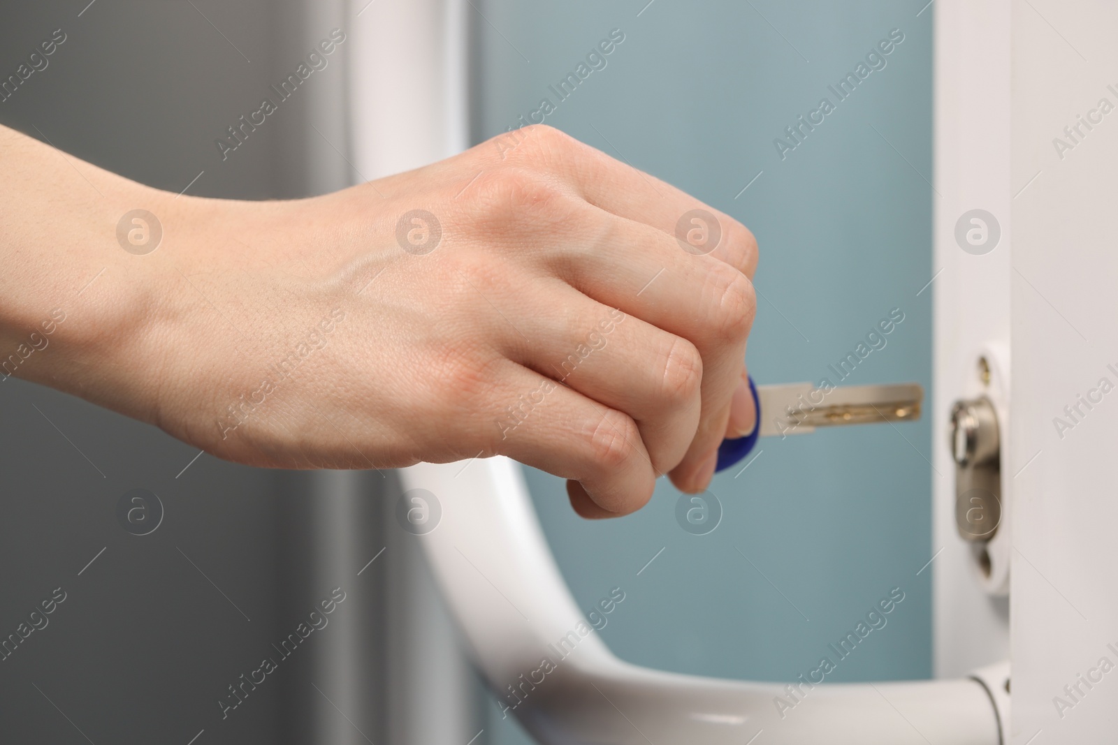 Photo of Woman unlocking door with key, closeup view