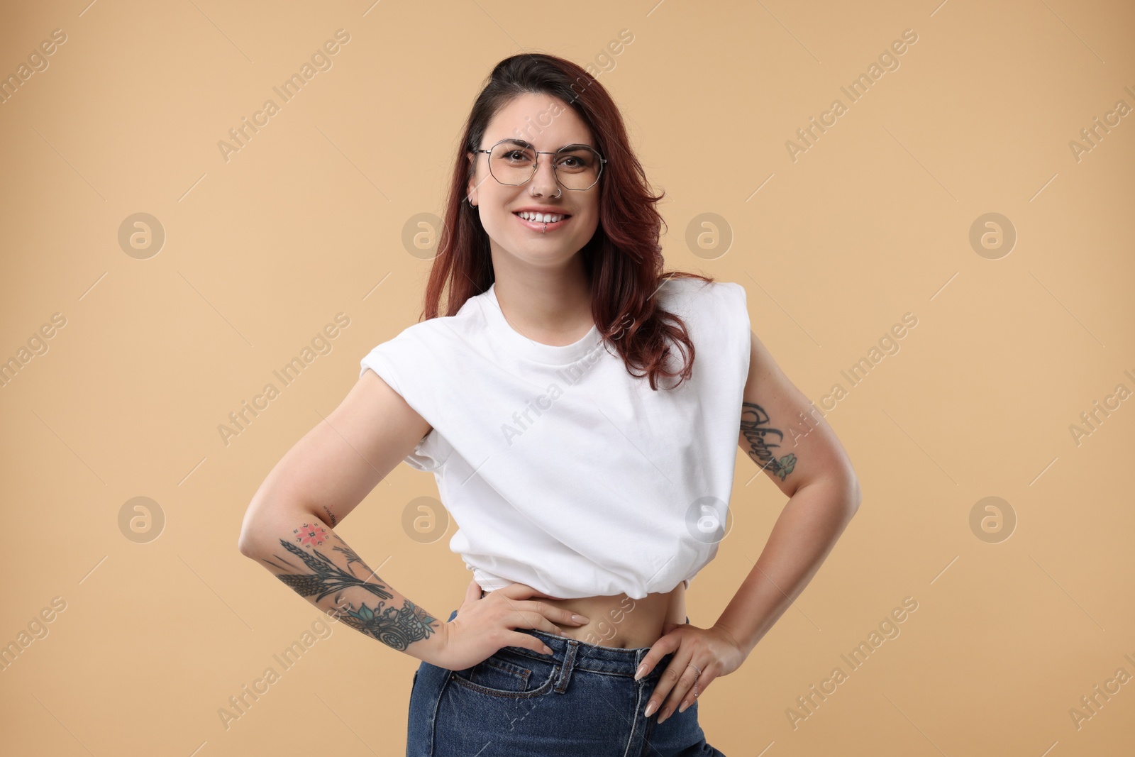 Photo of Portrait of beautiful tattooed woman on beige background