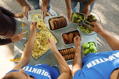 Photo of Volunteers serving food to poor people outdoors, top view