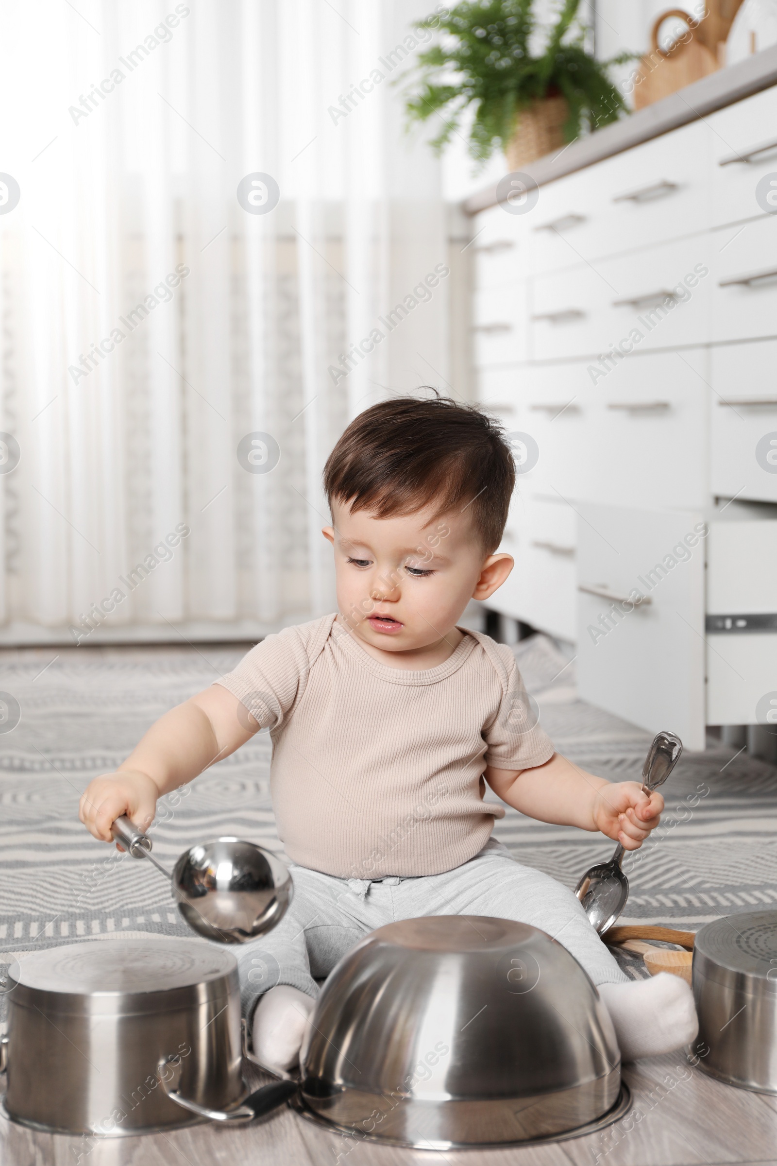 Photo of Cute little boy with cookware at home