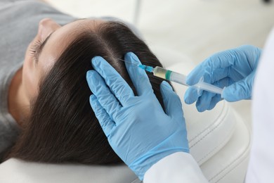 Trichologist giving injection to patient in clinic, closeup