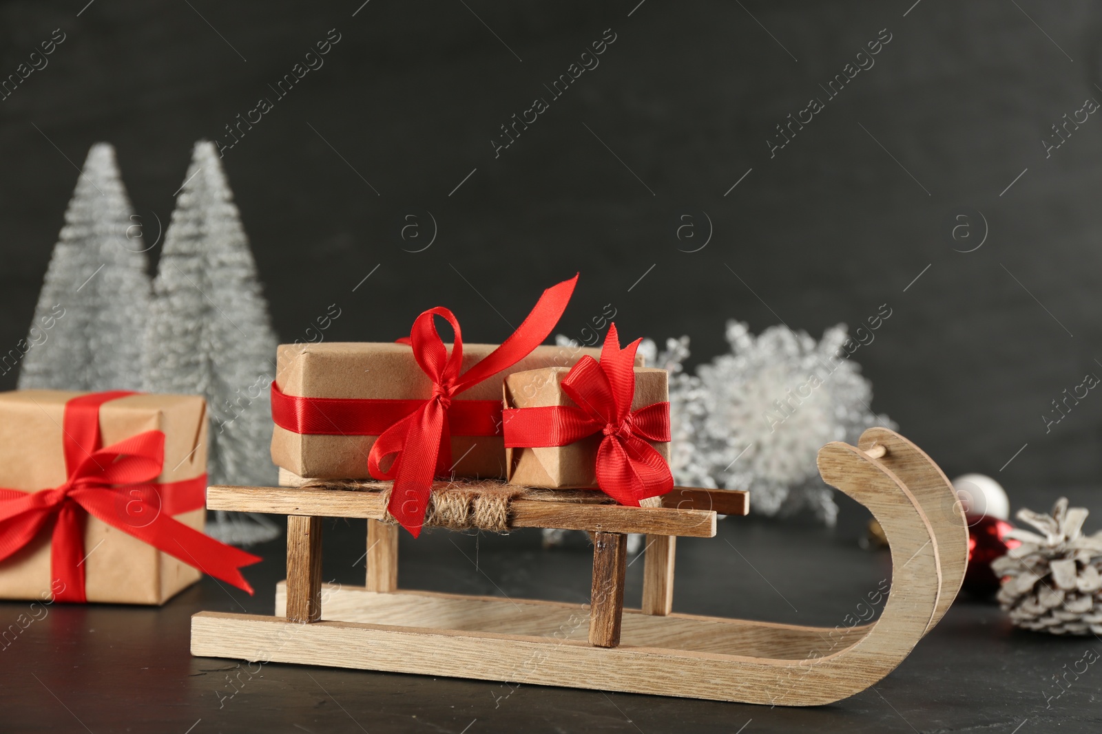 Photo of Beautiful Christmas composition with miniature sleigh on black slate table