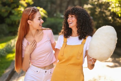 Photo of Happy friends with cotton candy in park on sunny day
