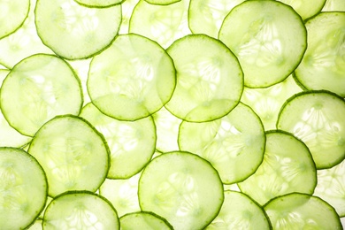 Photo of Slices of ripe cucumber as background, top view