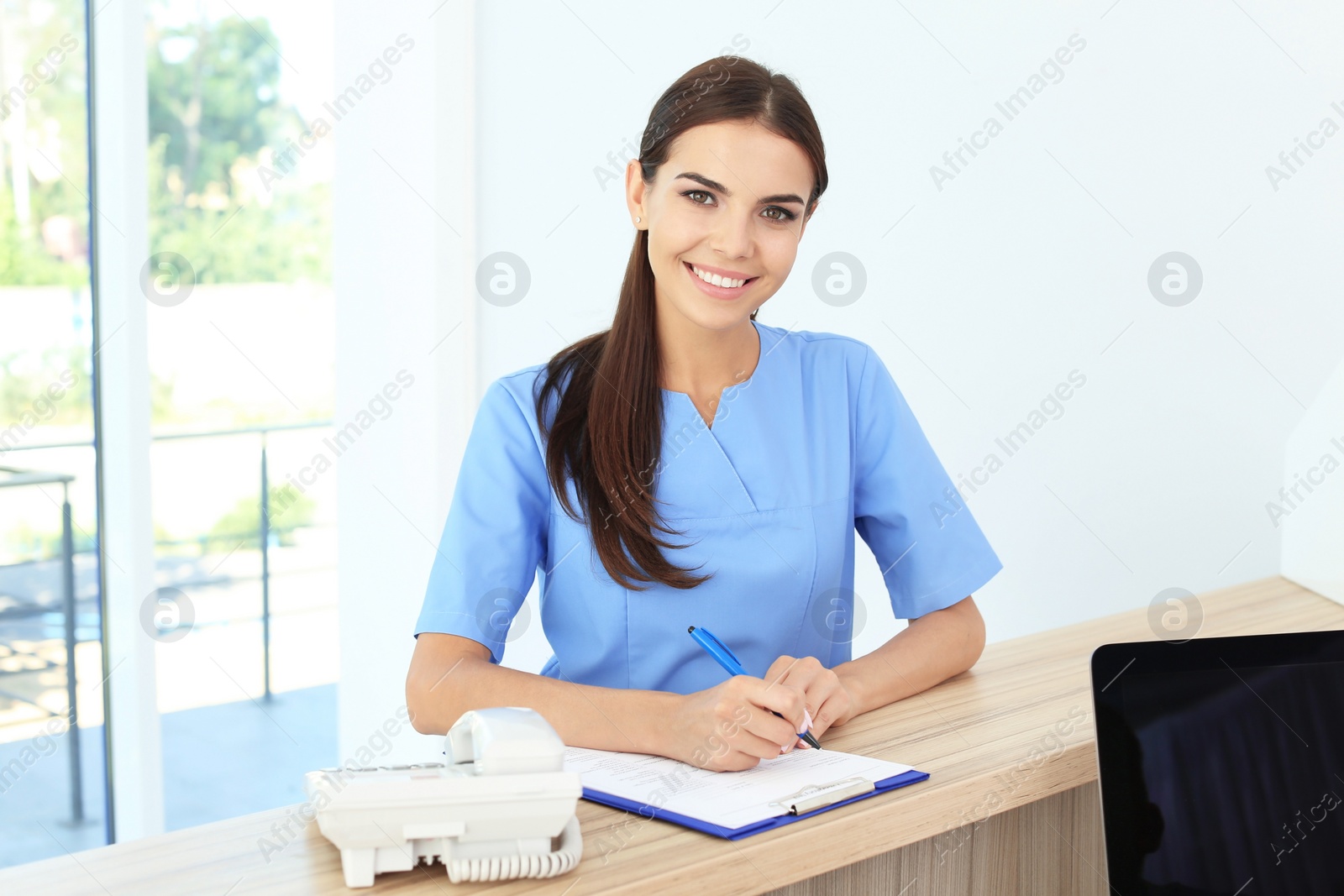 Photo of Female medical assistant at workplace in clinic. Health care service