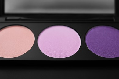 Beautiful eyeshadow palette as background, closeup. Professional cosmetic product