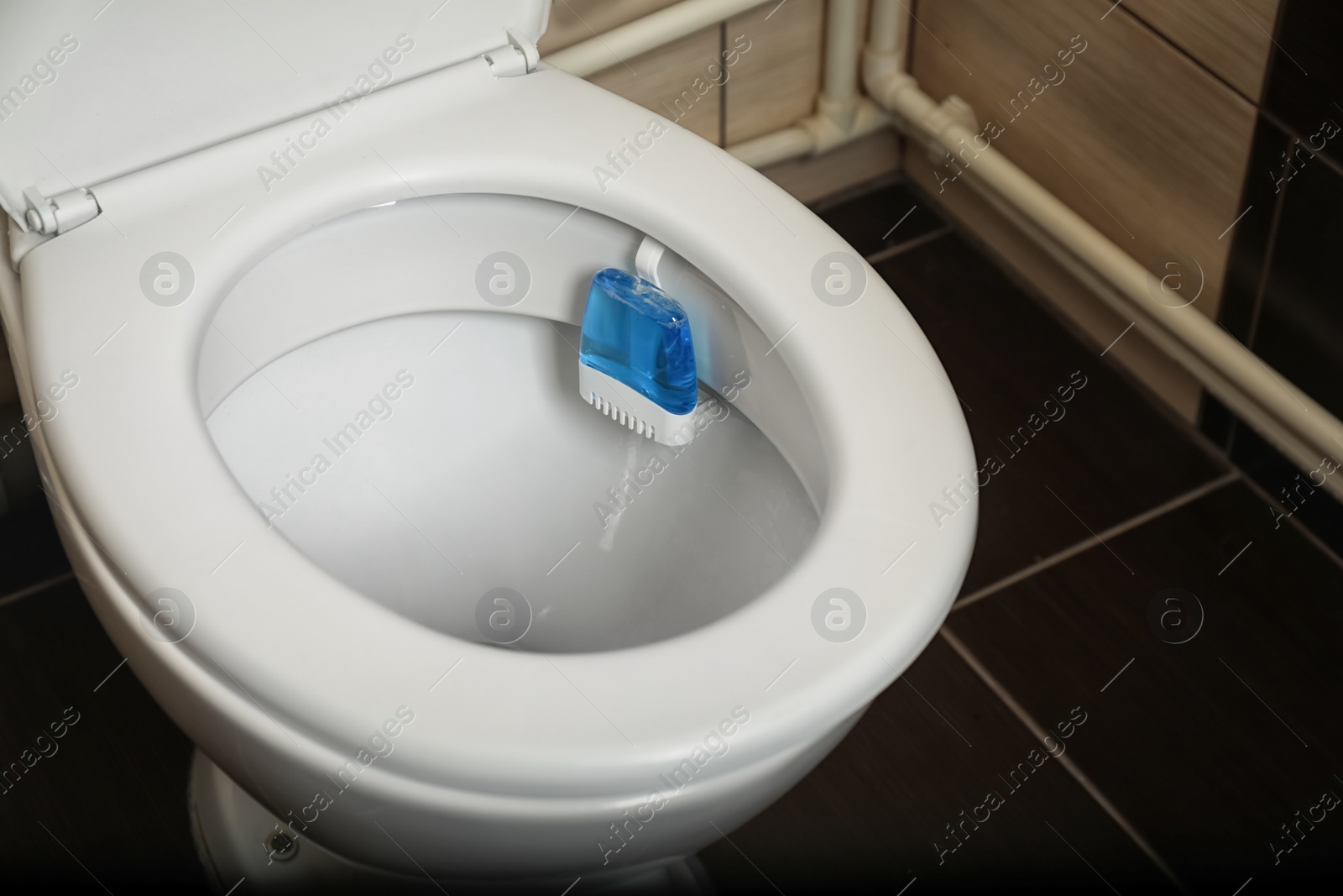 Photo of Toilet with rim block in bathroom. Air freshener