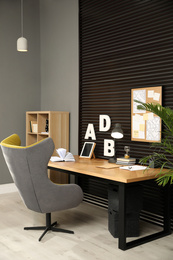 Comfortable workplace with office table and armchair. Stylish room interior