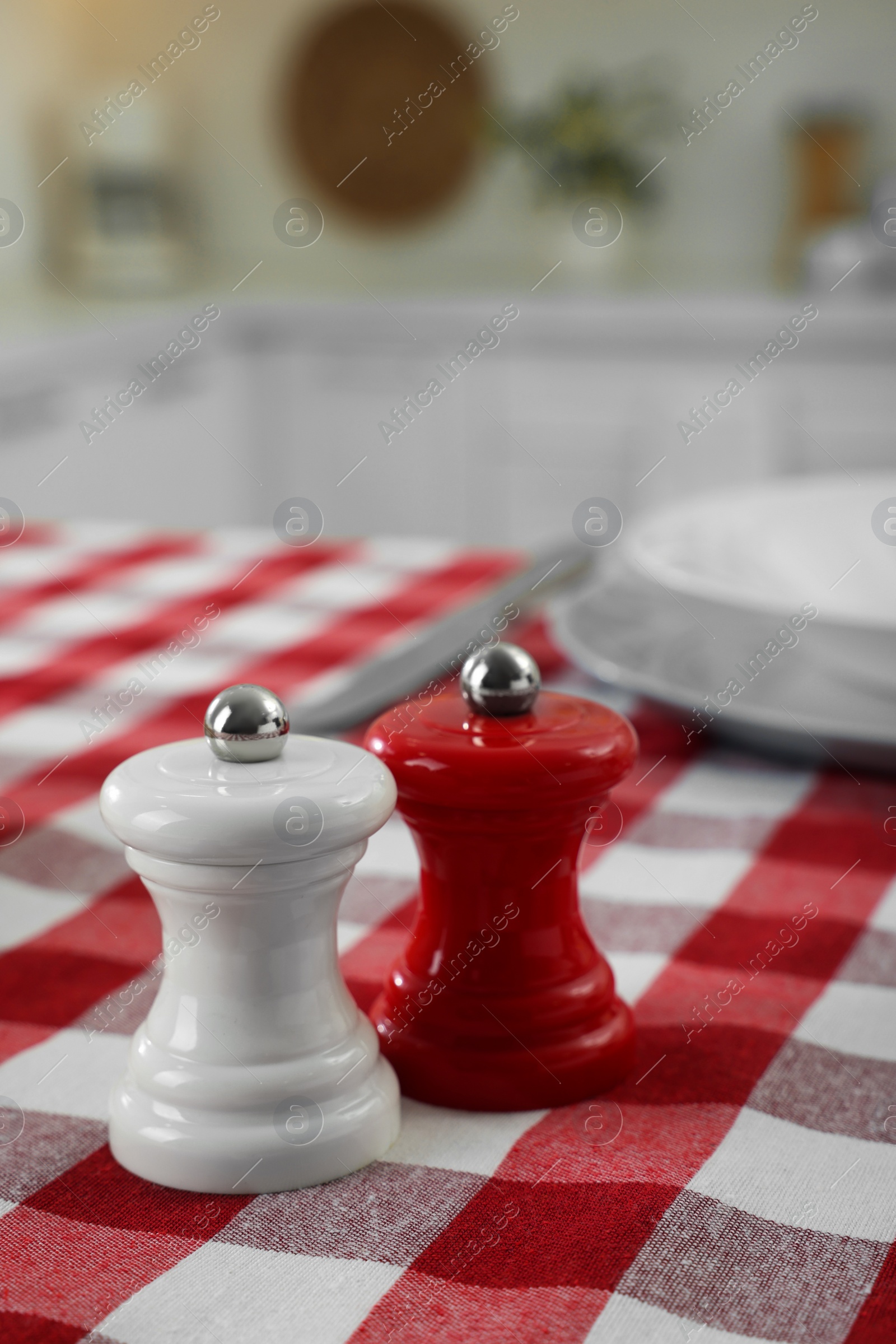 Photo of Ceramic salt and pepper mills on kitchen table. Space for text