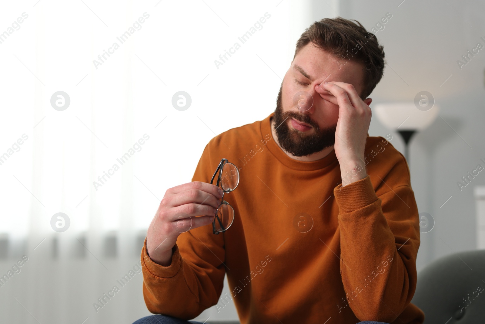 Photo of Overwhelmed man with glasses suffering at home. Space for text