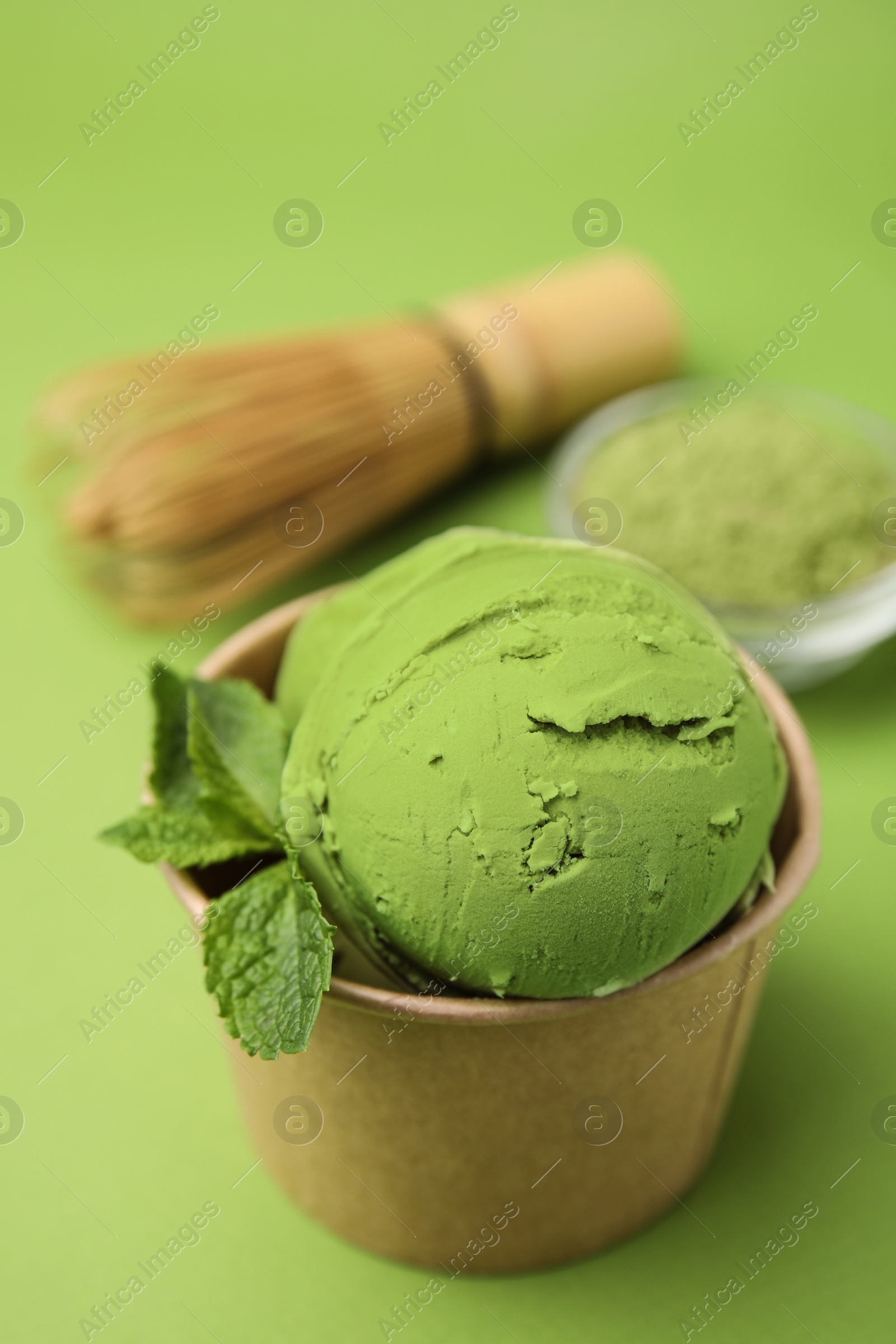 Photo of Paper cup with tasty matcha ice cream on light green background