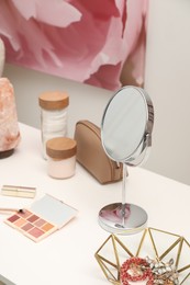 Dressing table with mirror, cosmetic products and jewelry in makeup room