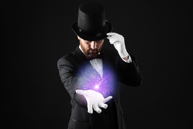 Magic and sorcery. Magician with fantastic light on dark background