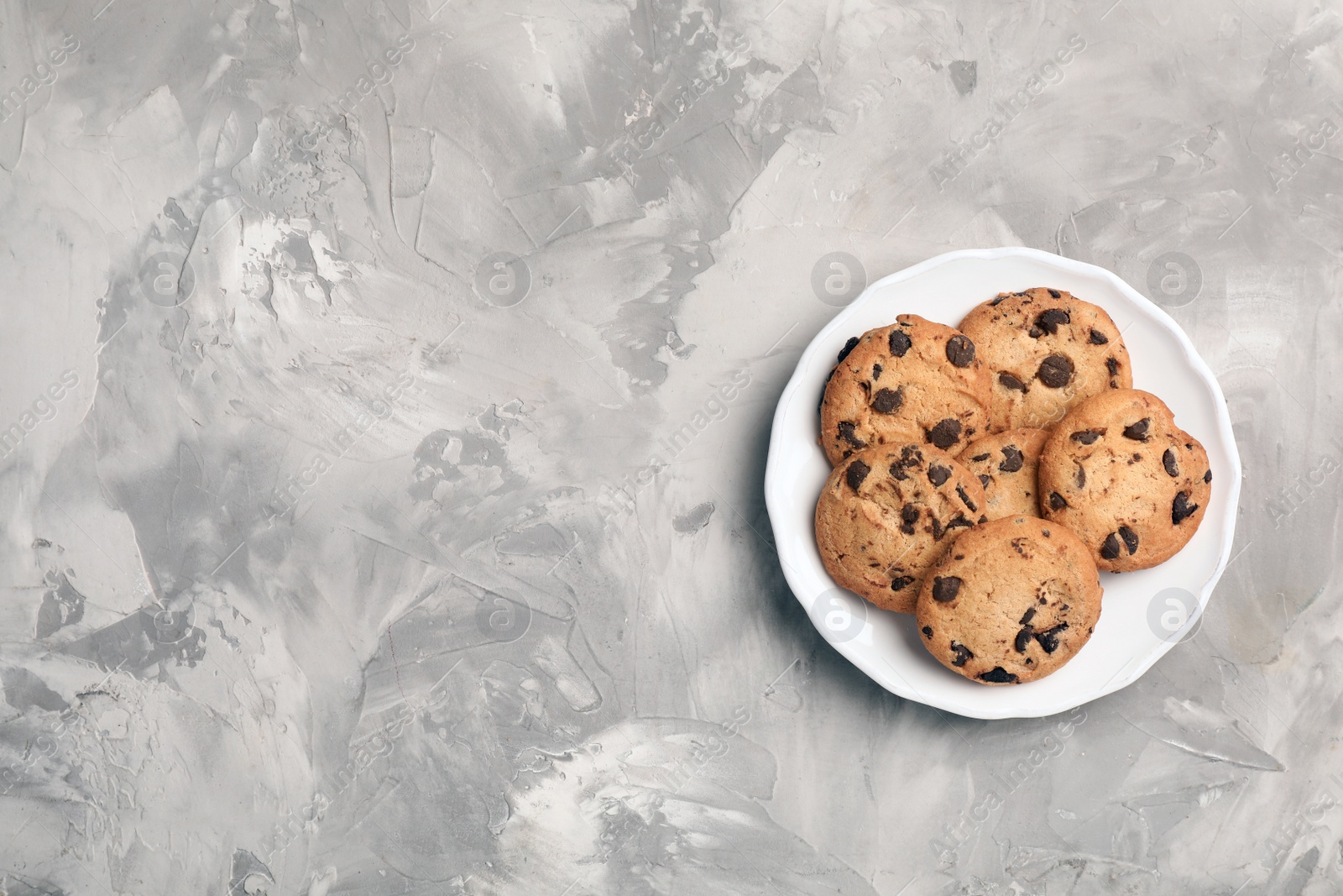 Photo of Plate with chocolate cookies and space for text on gray background, top view