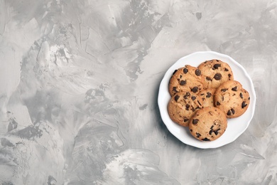 Photo of Plate with chocolate cookies and space for text on gray background, top view