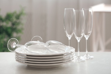 Set of clean dishware and champagne glasses on table indoors