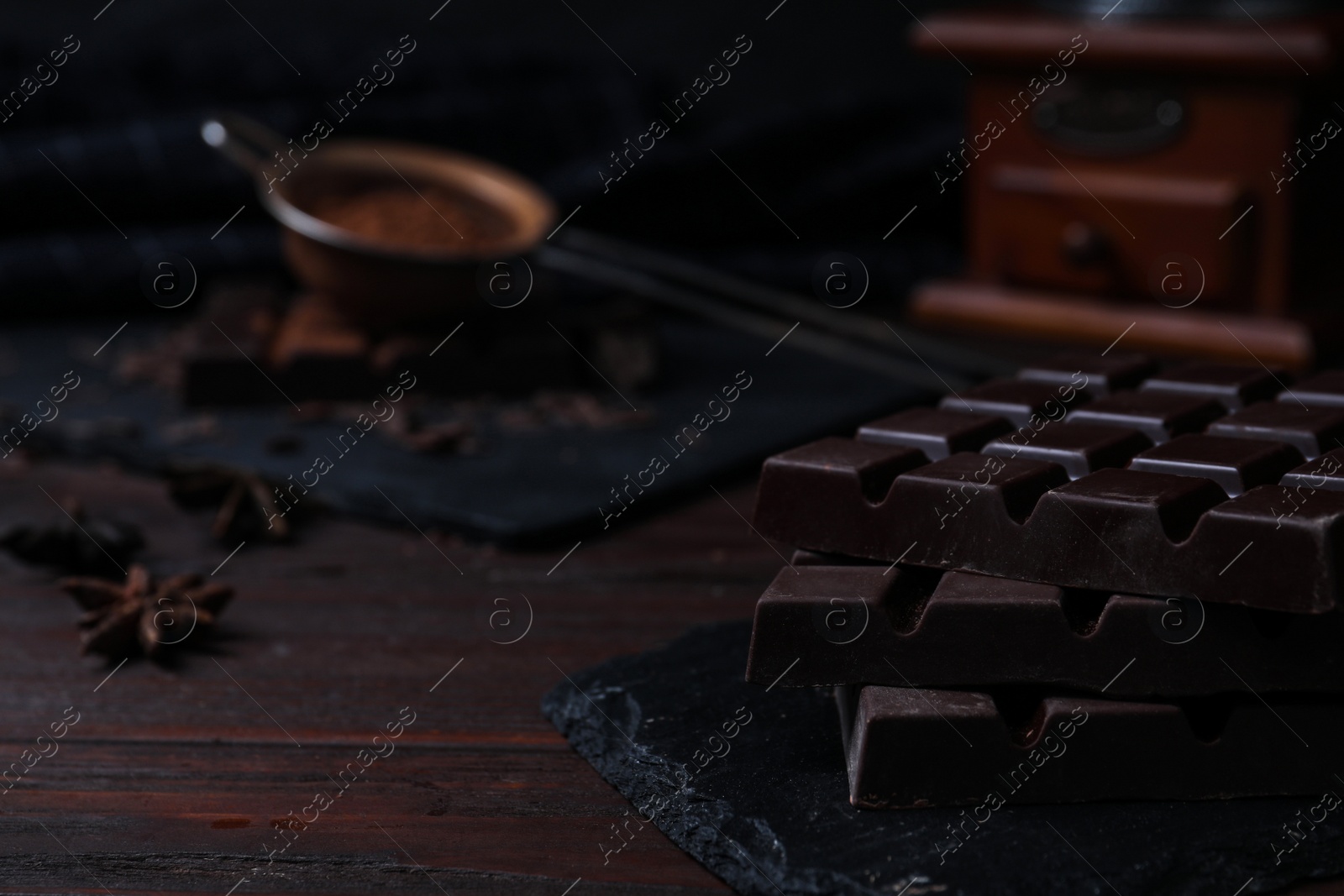 Photo of Tasty dark chocolate bars on wooden table, closeup