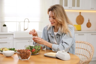 Photo of Woman with different healthy products at wooden table in kitchen. Keto diet