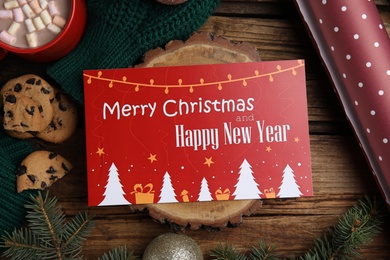 Photo of Flat lay composition with greeting card and Christmas decor on wooden background