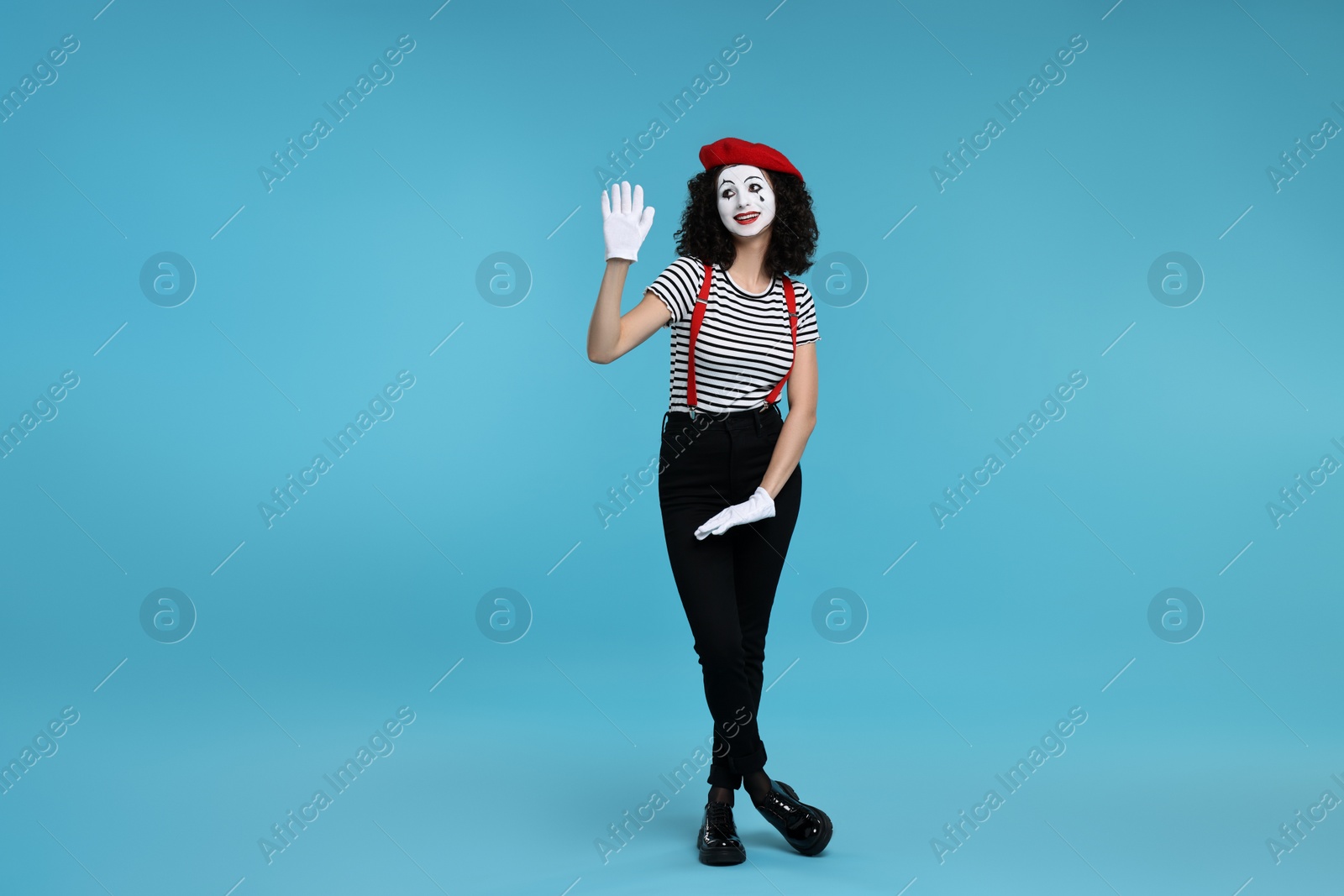 Photo of Funny mime with beret posing on light blue background