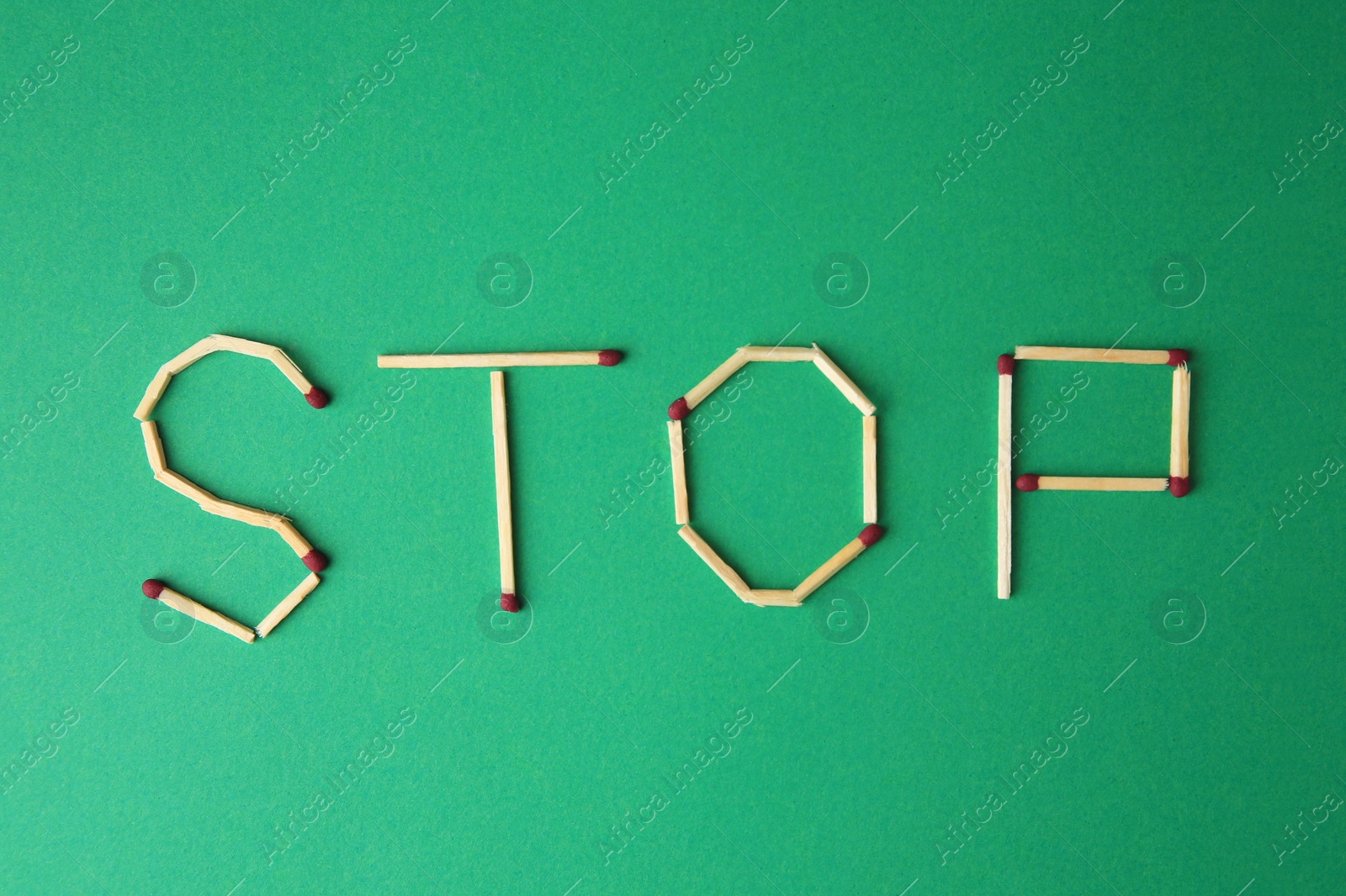 Photo of Word Stop made of matches on green background, flat lay. Stop smoking concept