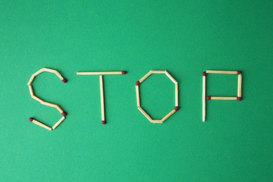 Photo of Word Stop made of matches on green background, flat lay. Stop smoking concept