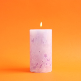 Alight scented wax candle on color background