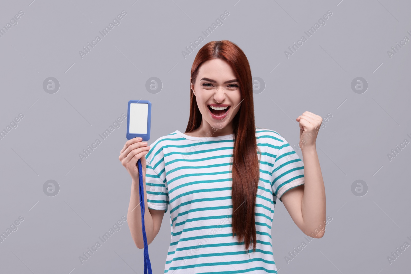 Photo of Emotional woman with vip pass badge on light grey background