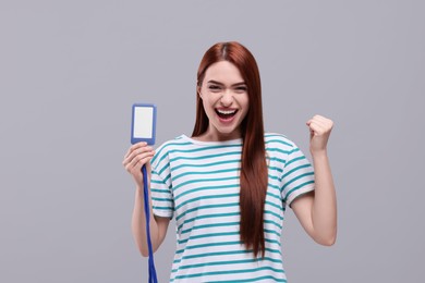 Emotional woman with vip pass badge on light grey background