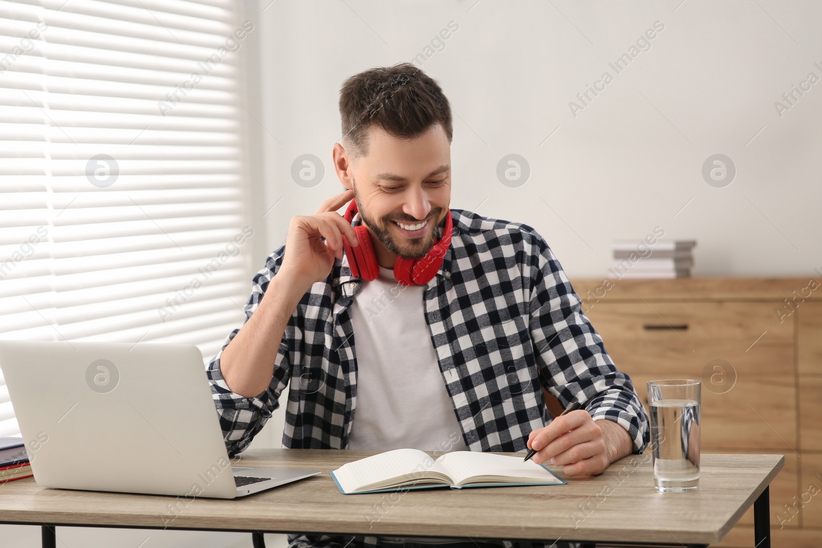 Photo of Man studying near laptop at home. Online translation course