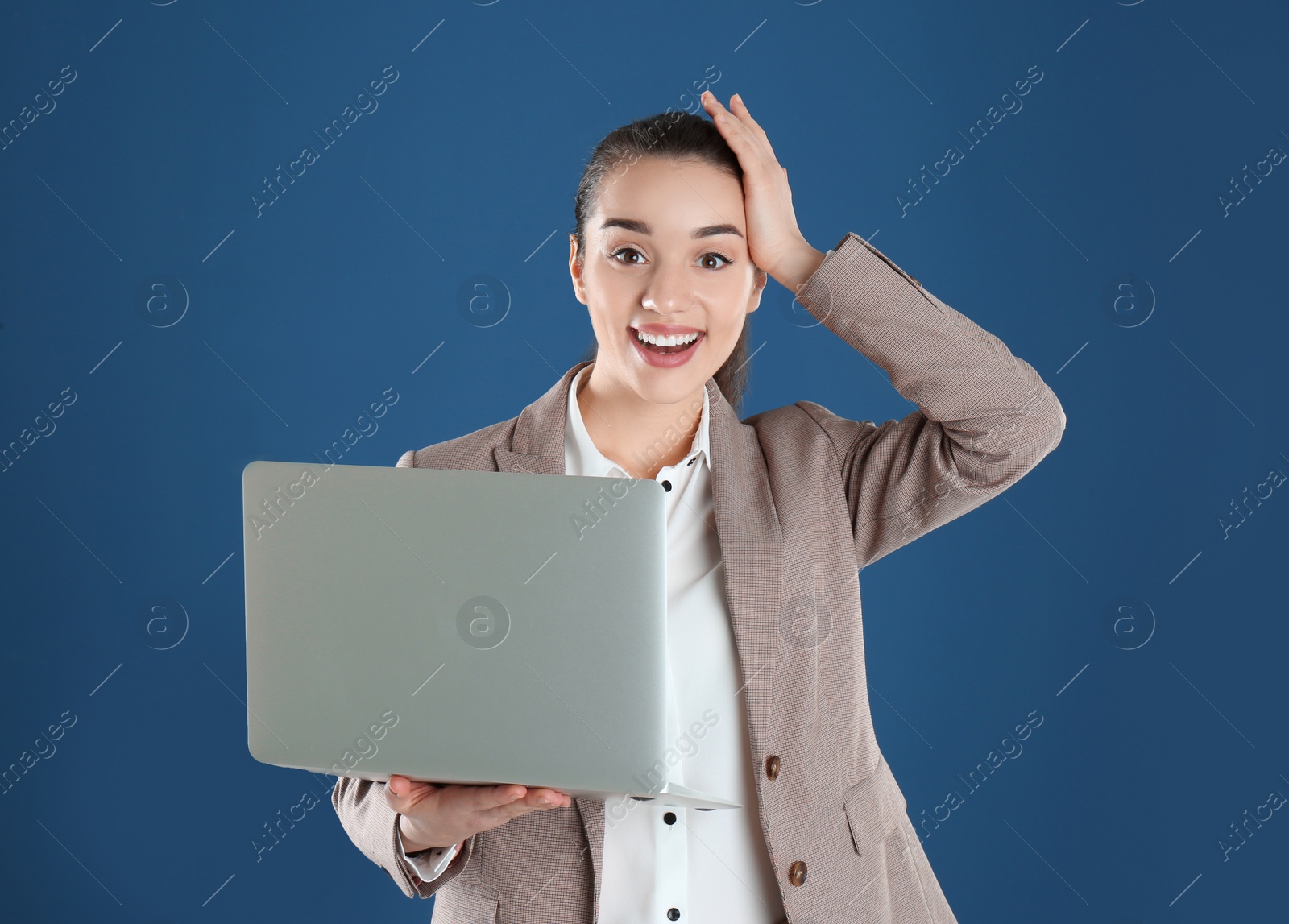 Photo of Portrait of happy young woman in office wear with laptop on color background