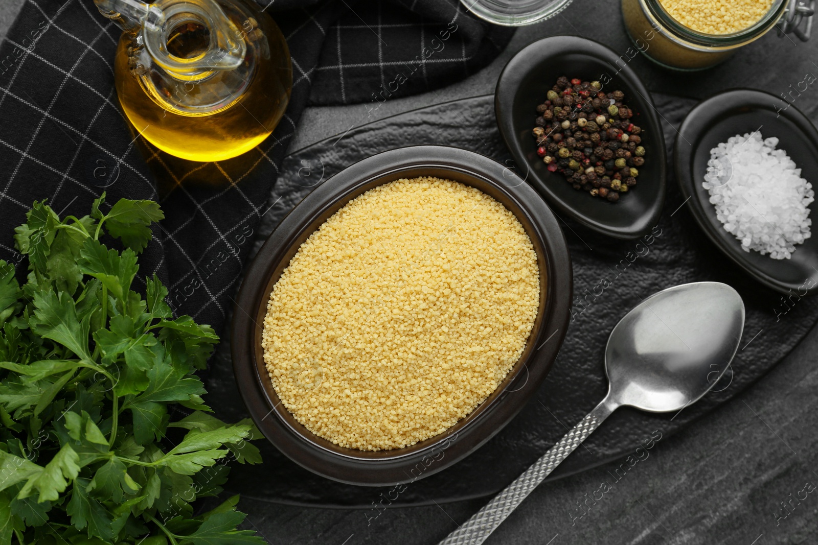 Photo of Raw couscous and ingredients on grey table, flat lay