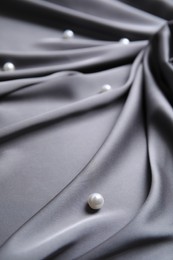 Many beautiful pearls on delicate black silk, closeup