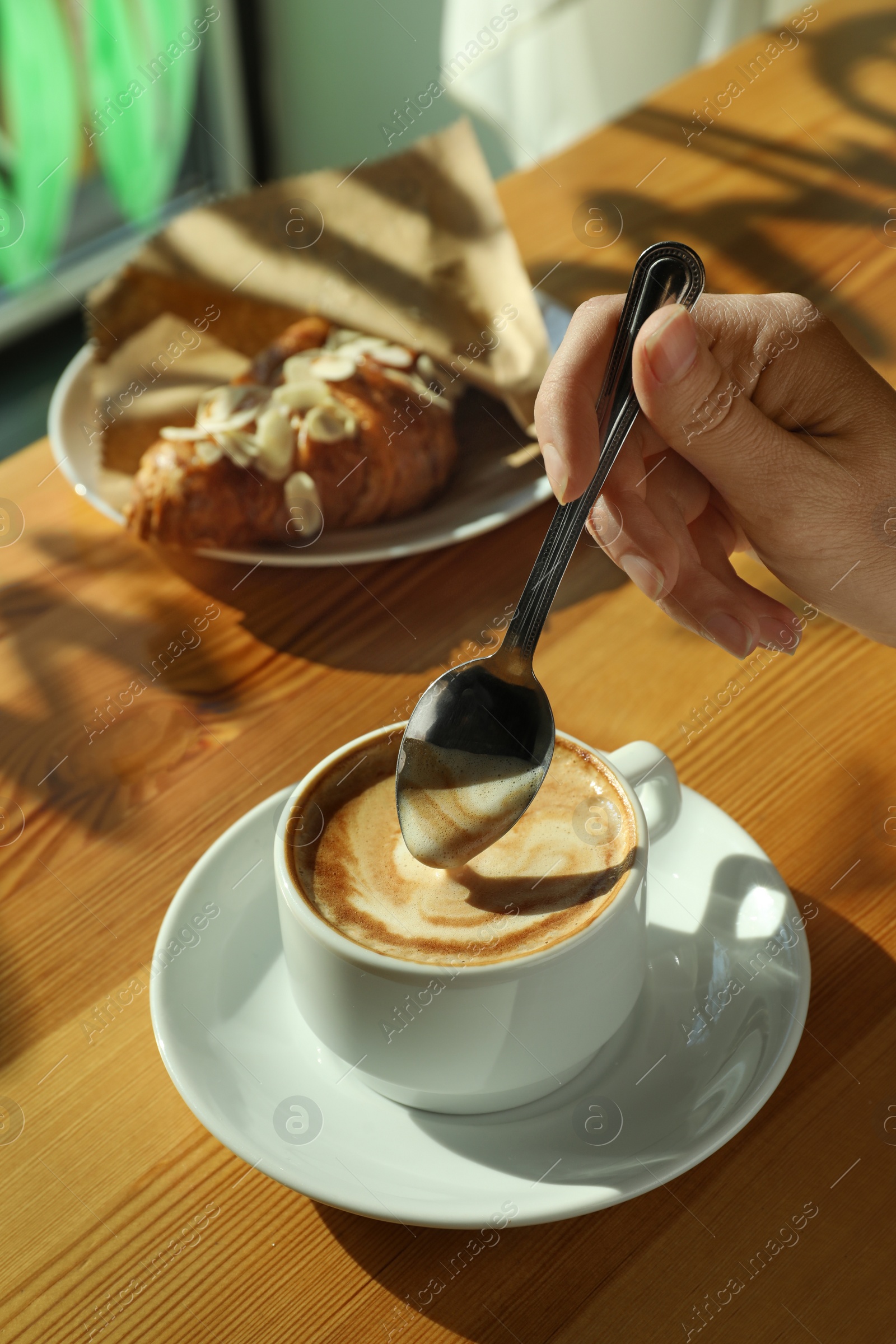 Photo of Woman with cup of fresh aromatic coffee at table in cafe