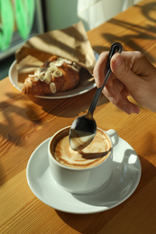 Photo of Woman with cup of fresh aromatic coffee at table in cafe