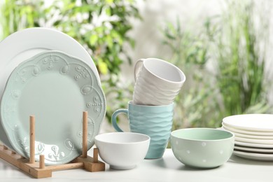 Photo of Beautiful ceramic dishware and cup on white table outdoors