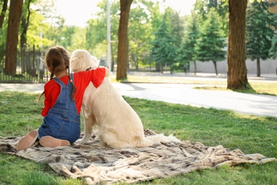 Cute little child with his pet in green park