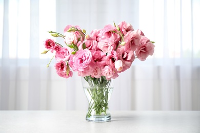 Beautiful pink Eustoma flowers in vase on table indoors