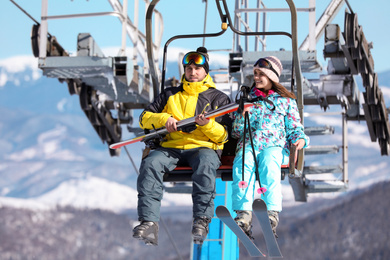 People using chairlift at mountain ski resort. Winter vacation