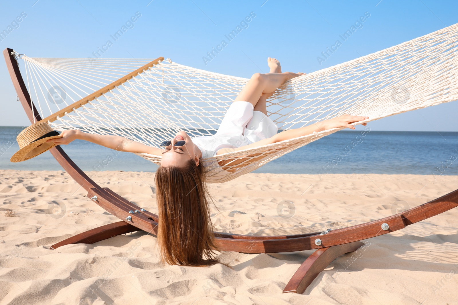 Photo of Young woman relaxing in hammock on beach