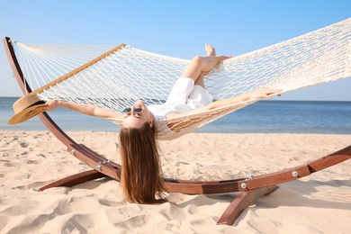 Young woman relaxing in hammock on beach