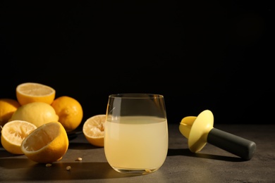 Photo of Composition with glass of freshly squeezed lemon juice on table