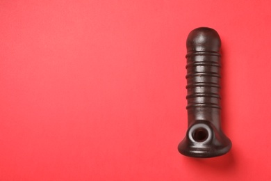 Photo of Dildo on red background, top view with space for text. Sex toy
