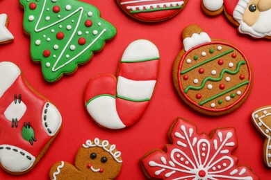 Different tasty Christmas cookies on red background, flat lay